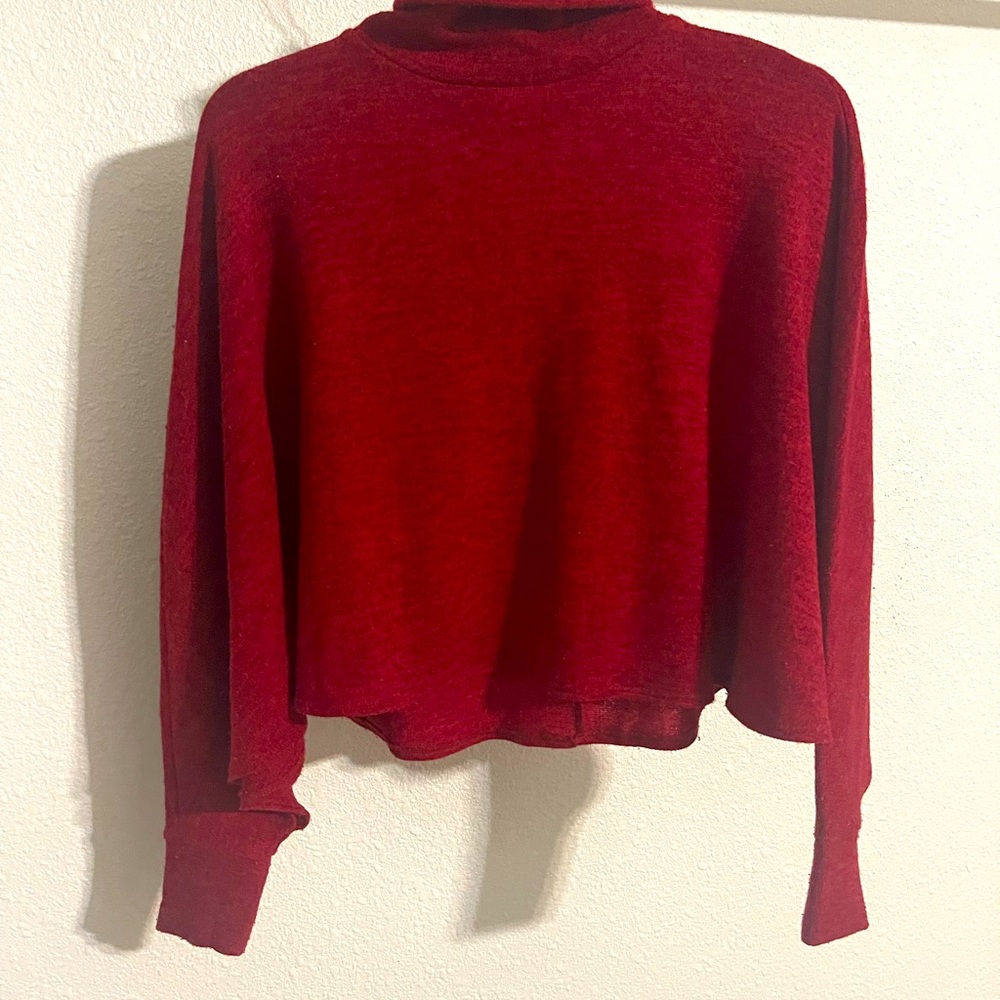 Blusa roja, cuello alto tipo capa.